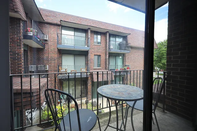 a view of a patio with table and chairs with wooden floor and fence