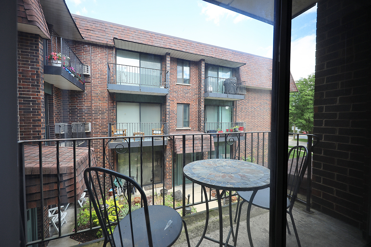 4946 Douglas Road, Unit 202 Downers Grove, IL 60515 - Photo 16 of 19 a view of a patio with table and chairs with wooden floor and fence