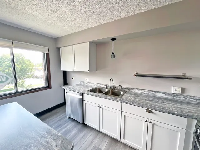 a kitchen with a sink cabinets and window