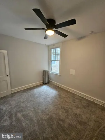 an empty room with a window and a ceiling fan