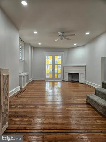 a view of empty room with wooden floor and fireplace