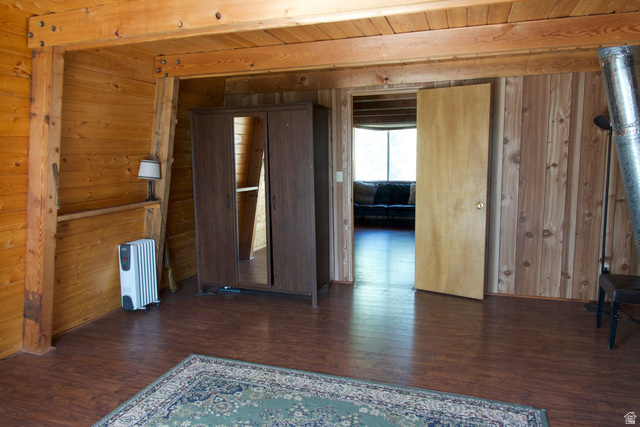 140 East Rim Road Duck Creek Village, UT 84762 - Photo 39 of 45 Empty room with dark wood-style floors, wooden ceiling, radiator heating unit, and wooden walls
