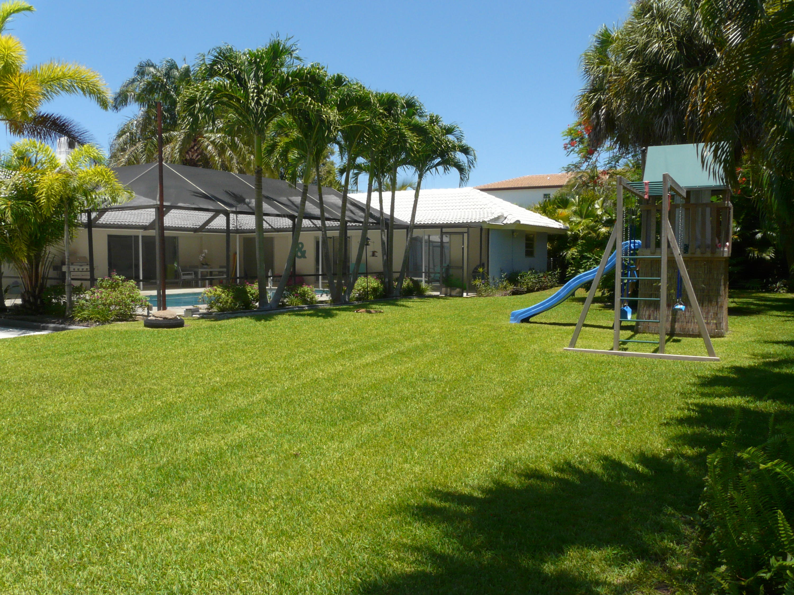 1120 Southwest 15th Street Boca Raton, FL 33486 - Photo 14 of 32 a view of a backyard with a slide and a bench