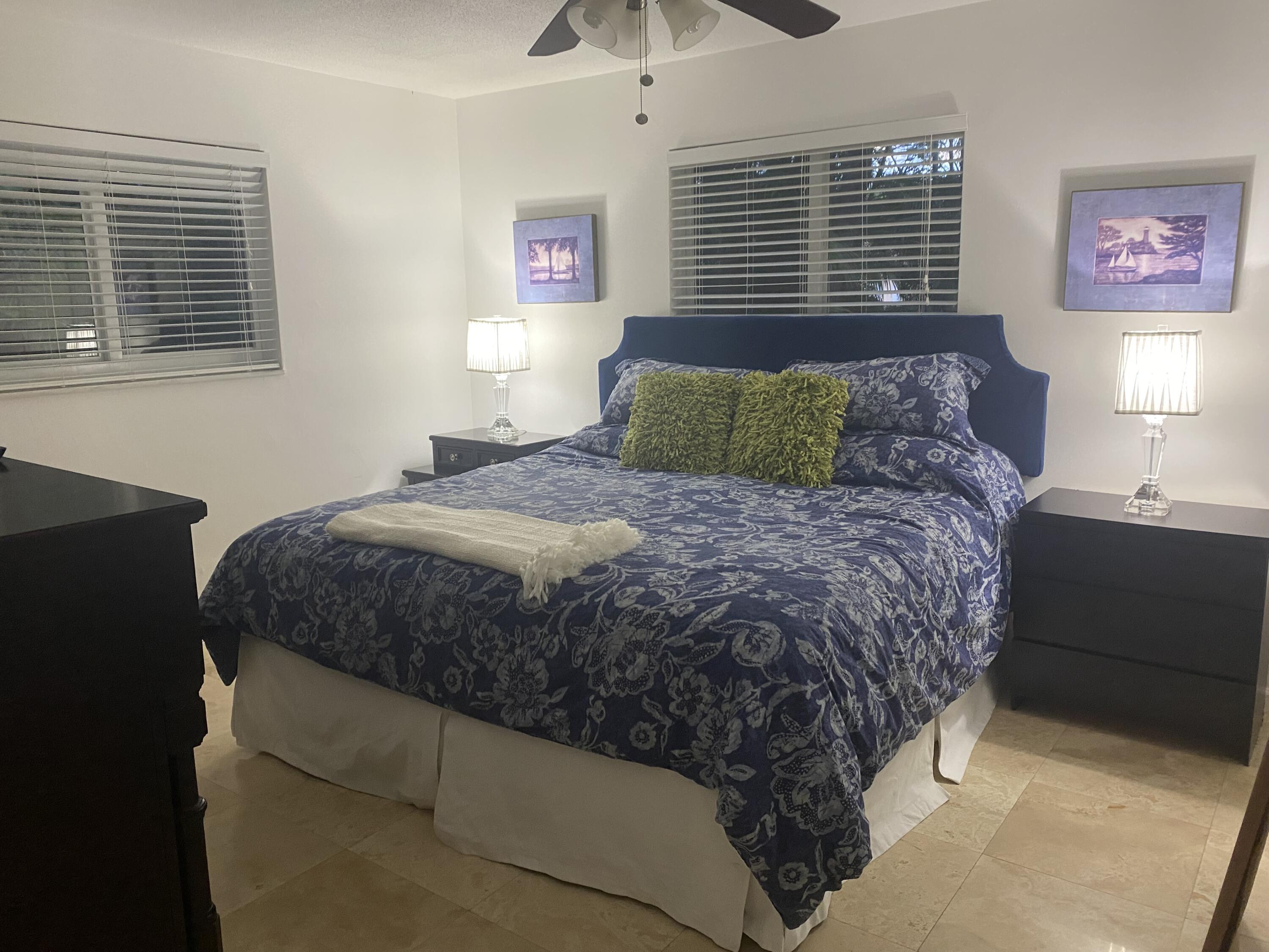 1120 Southwest 15th Street Boca Raton, FL 33486 - Photo 16 of 32 a large bed sitting in a bedroom next to a window and a chandelier