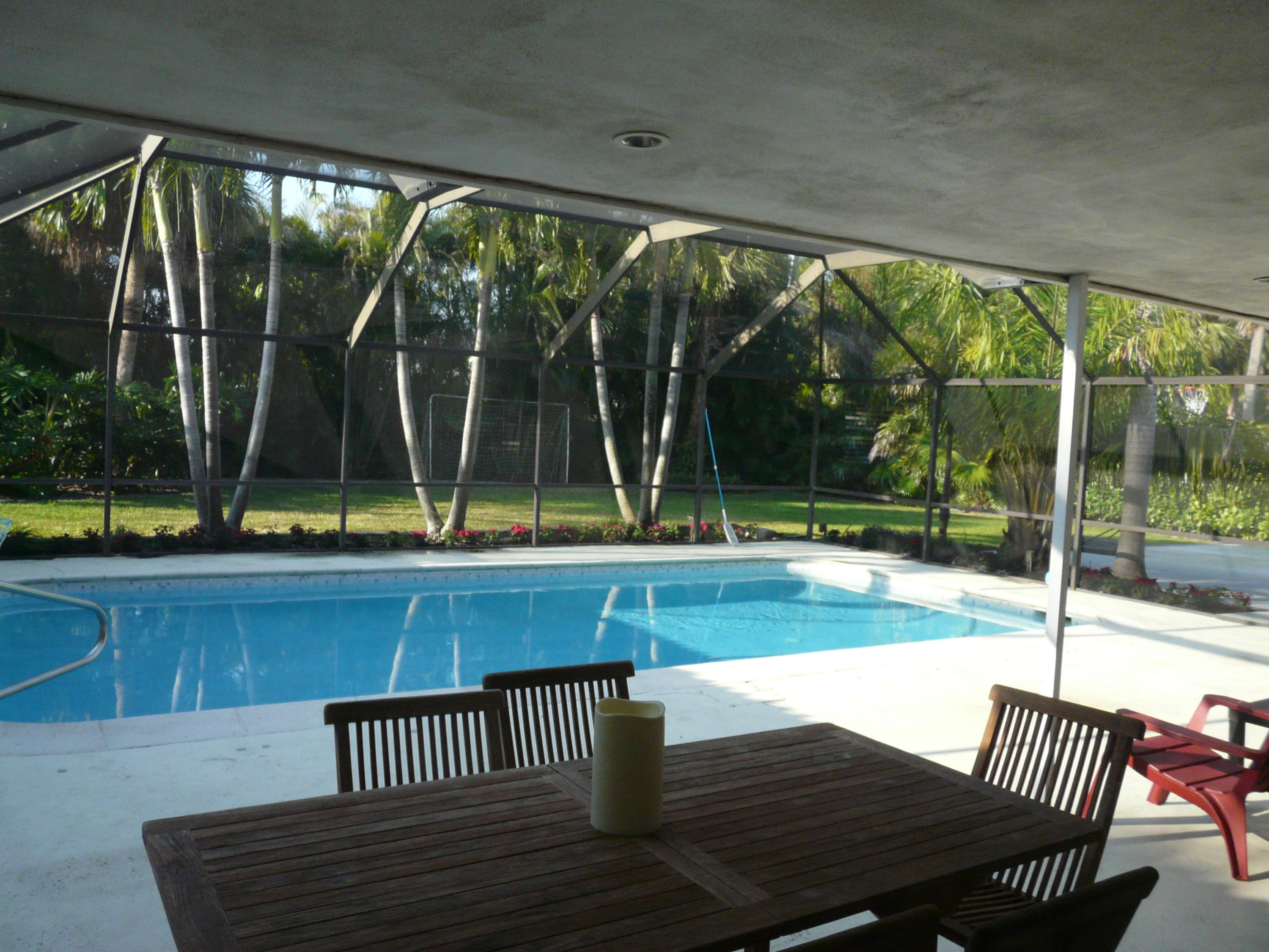 1120 Southwest 15th Street Boca Raton, FL 33486 - Photo 21 of 32 a view of swimming pool with a table and chairs next to a yard