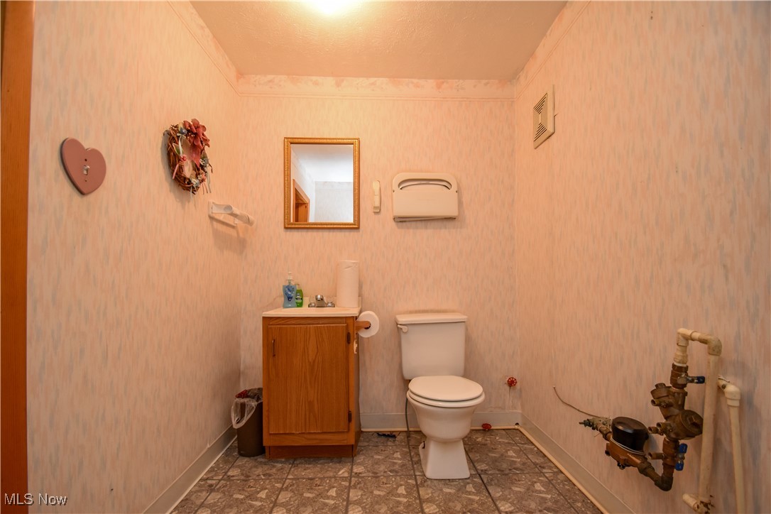 1187 Deforest Road Southeast Warren, OH 44484 - Photo 40 of 42 Half bath featuring toilet, vanity, and baseboards