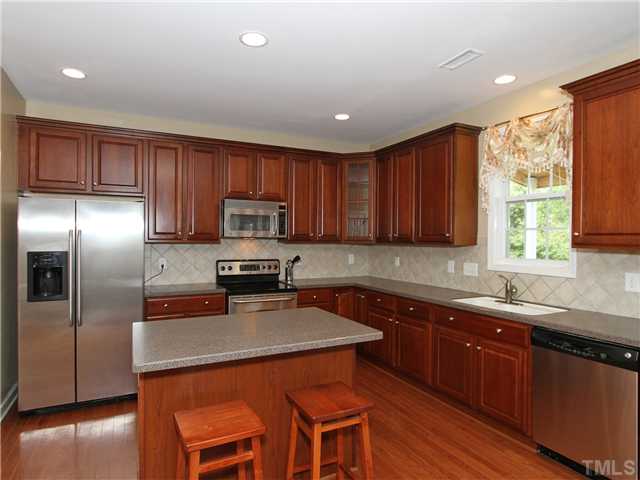 5232 Holly Ridge Farm Road Raleigh, NC 27616 - Photo 5 of 22 42" Cherry Cabinets with Tile Backsplash. A great deal of countertop space and note the updated stainless steel appliances.