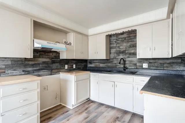 a kitchen with granite countertop white cabinets and white appliances