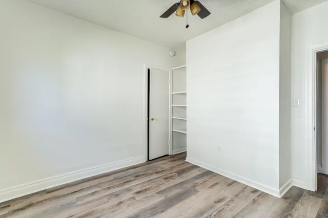 an empty room with a window and ceiling fan