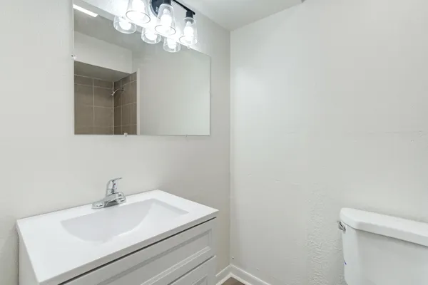 a bathroom with a sink a mirror and a toilet