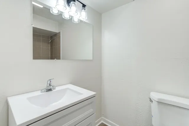 a bathroom with a sink a mirror and a toilet