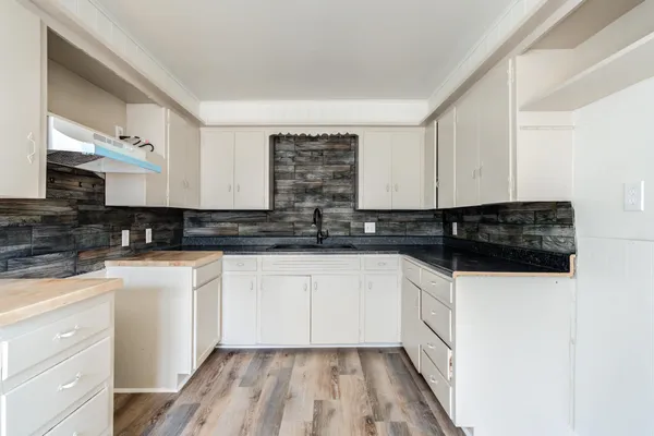 a kitchen with granite countertop a sink and cabinets