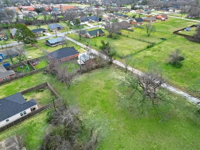 an aerial view of residential houses with outdoor space and trees