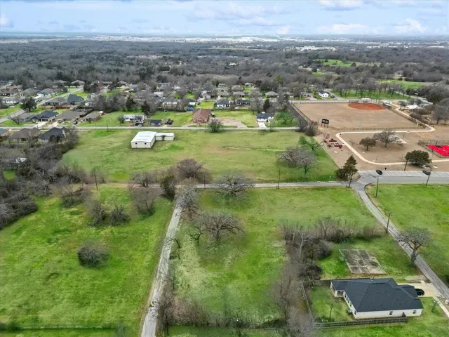 an aerial view of residential houses with outdoor space and trees