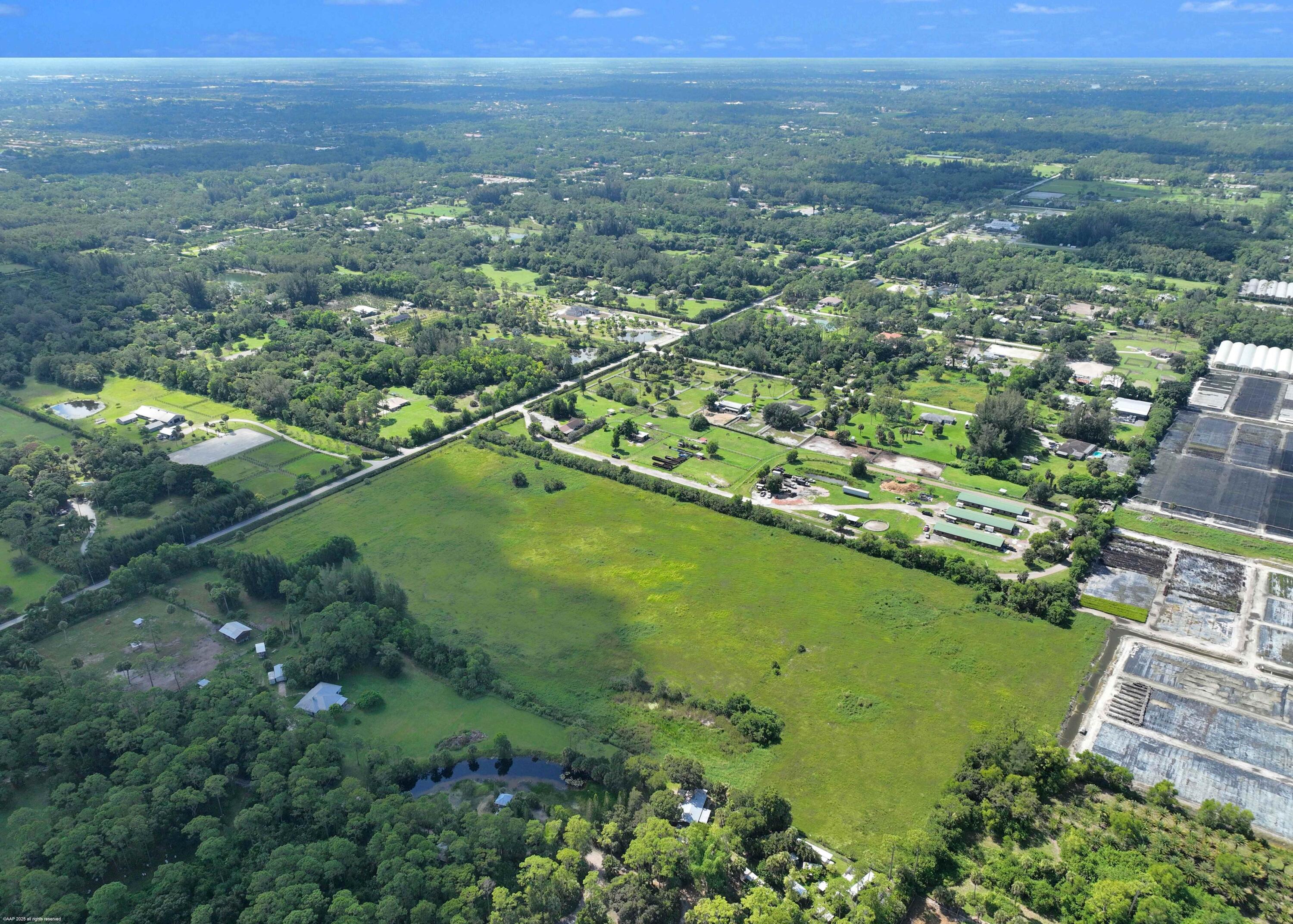 2761 E Road Loxahatchee Groves, FL 33470 - Photo 17 of 20 an aerial view of residential houses with outdoor space and trees