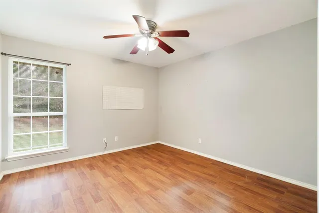 an empty room with closet and ceiling fan