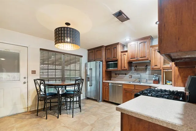 a kitchen with refrigerator and chairs