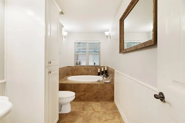 a bathroom with a granite countertop toilet a sink and a mirror