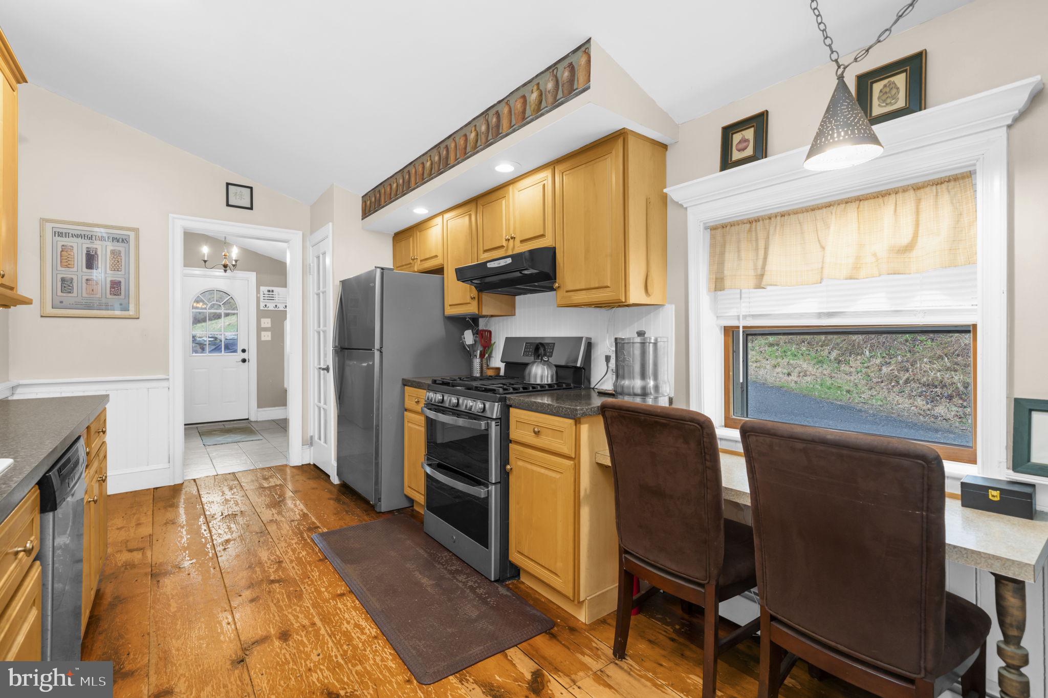 103 Gravel Pike Green Lane, PA 18054 - Photo 10 of 43 a kitchen with stainless steel appliances granite countertop a refrigerator a stove a sink dishwasher and white cabinets with wooden floor