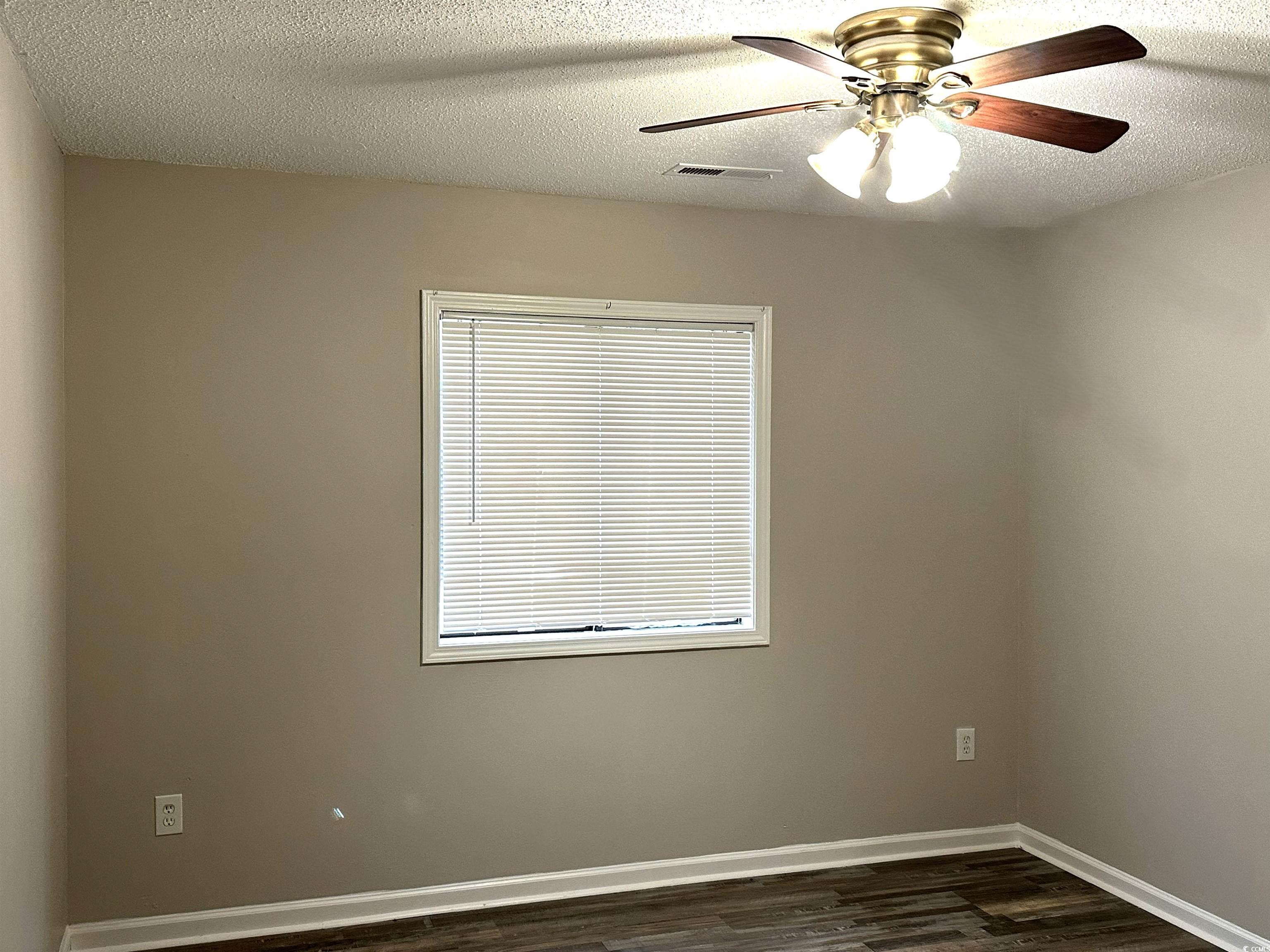 178 Beaver Pond Loop, Unit 60 Pawleys Island, SC 29585 - Photo 11 of 21 Empty room with a ceiling fan, a textured ceiling, and dark wood-type flooring