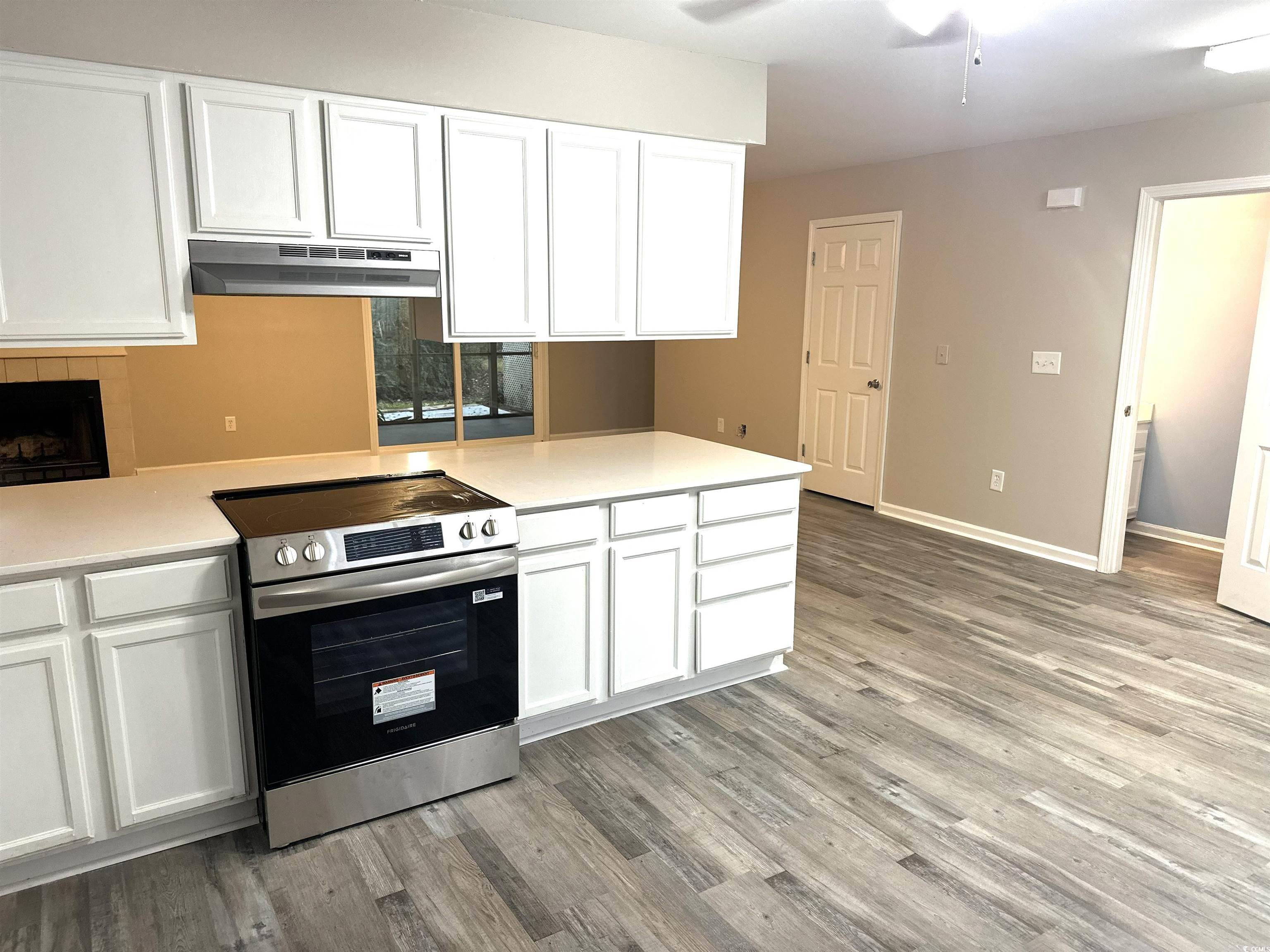 178 Beaver Pond Loop, Unit 60 Pawleys Island, SC 29585 - Photo 14 of 21 Kitchen featuring white cabinets, stainless steel electric range, under cabinet range hood, light wood finished floors, and ceiling fan