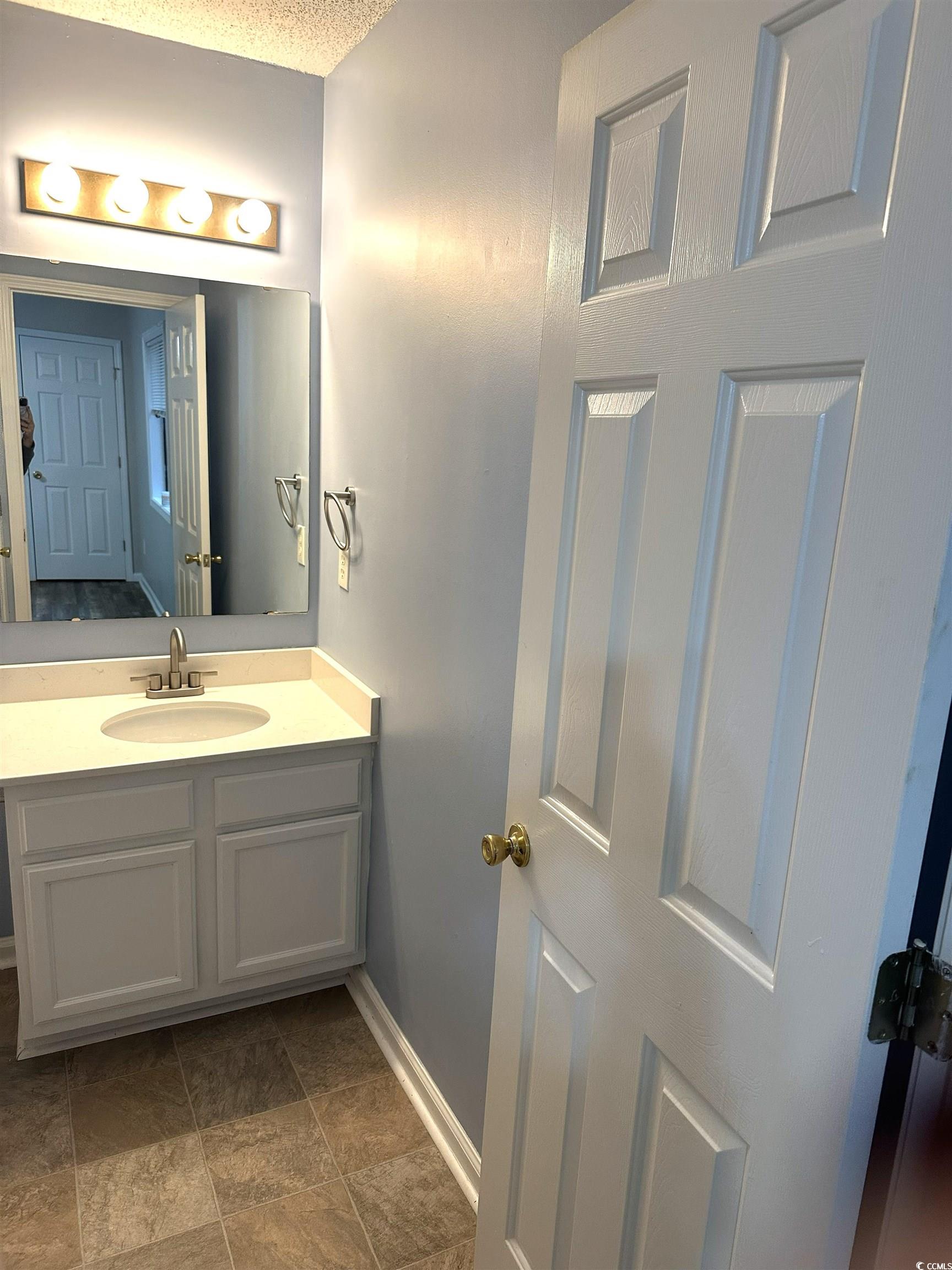 178 Beaver Pond Loop, Unit 60 Pawleys Island, SC 29585 - Photo 20 of 21 Unfurnished bedroom featuring dark wood-type flooring, a closet, a textured ceiling, and a ceiling fan