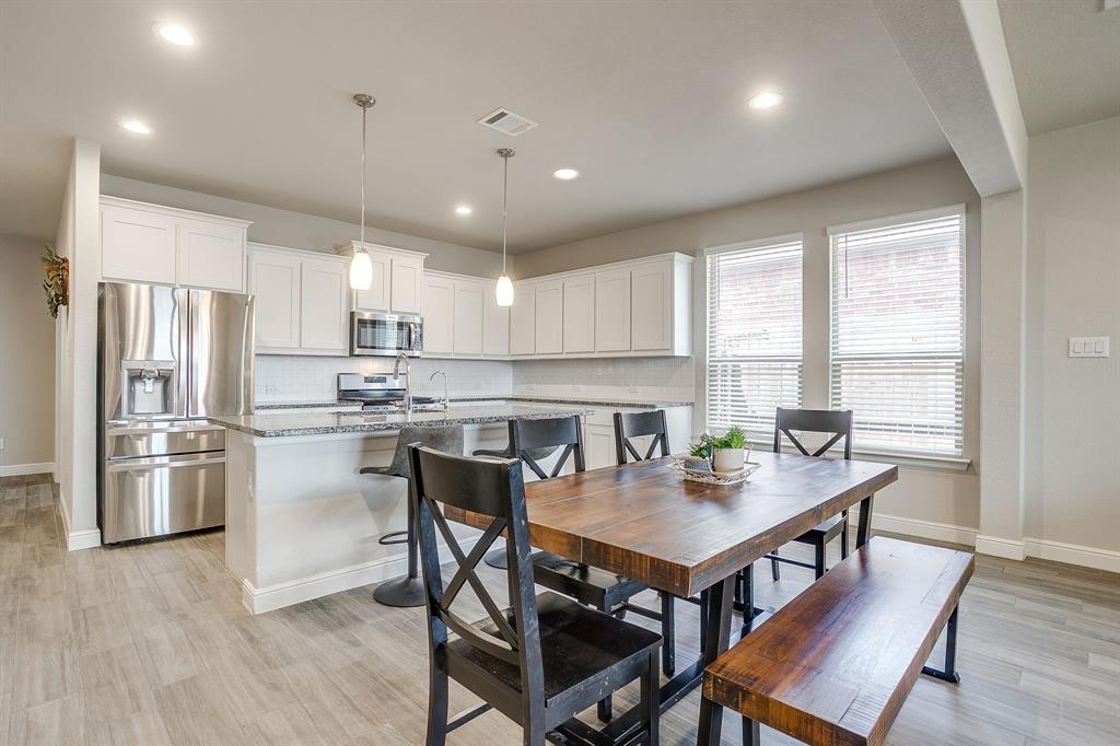 2361 Waggoner Rnch Drive Weatherford, TX 76087 - Photo 6 of 19 a kitchen with a dining table chairs refrigerator and microwave