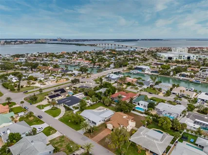 a white house that has a small yard and a large parking space