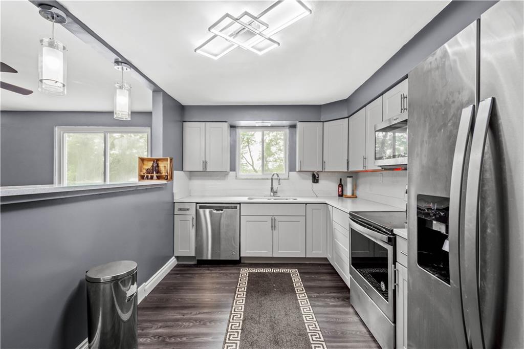 449 Decatur Avenue Pittsburgh, PA 15221 - Photo 4 of 24 a kitchen with granite countertop stainless steel appliances a sink stove and refrigerator