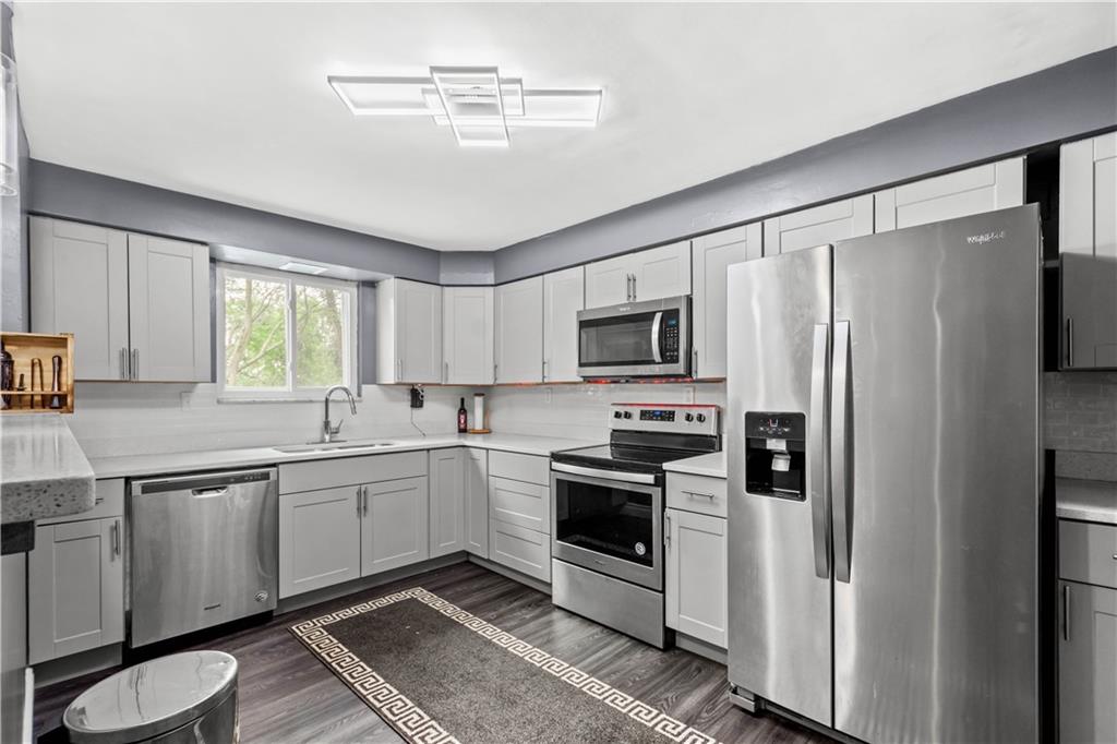 449 Decatur Avenue Pittsburgh, PA 15221 - Photo 5 of 24 a kitchen with stainless steel appliances a stove sink and microwave