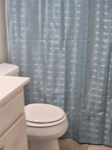 a white toilet sitting next to a shower curtain