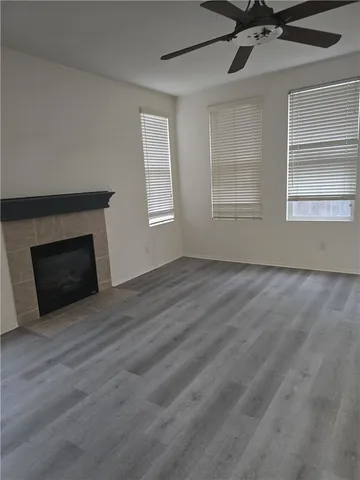 a view of an empty room with a fireplace and a window