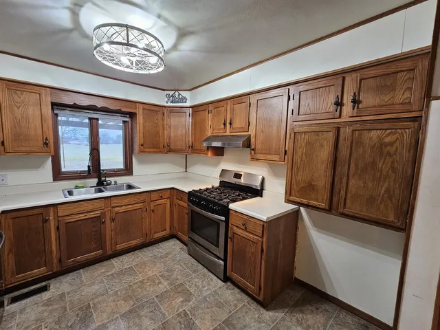a kitchen with stainless steel appliances granite countertop a stove sink and cabinets