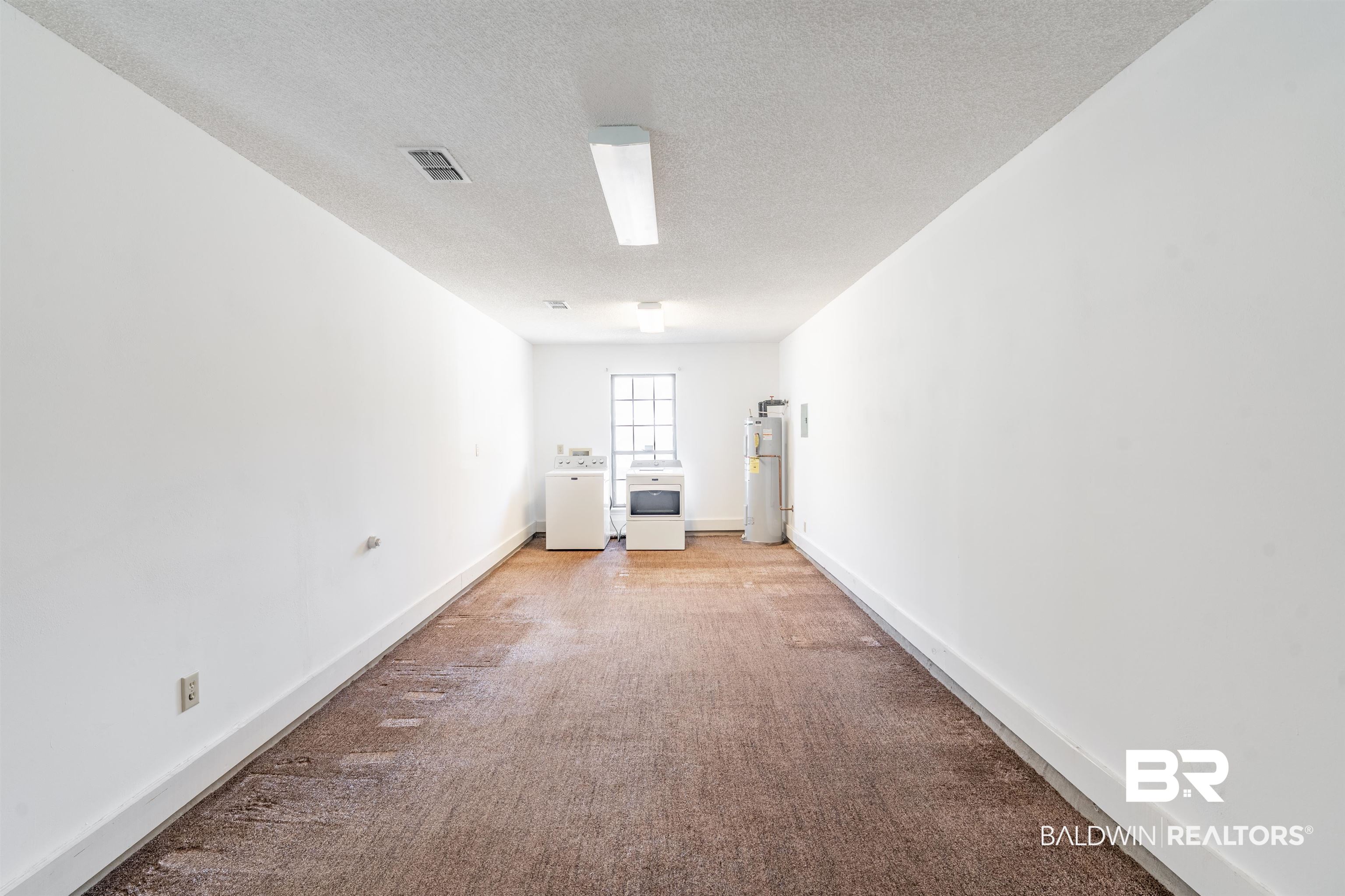 9751 Pine Knoll Road Mobile, AL 36608 - Photo 28 of 36 Carpeted empty room with a textured ceiling, separate washer and dryer, and water heater