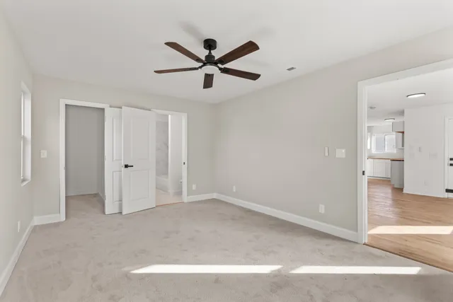 a view of empty room with wooden floor and ceiling fan
