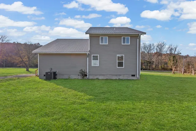 a view of a backyard with barn plants and large tree