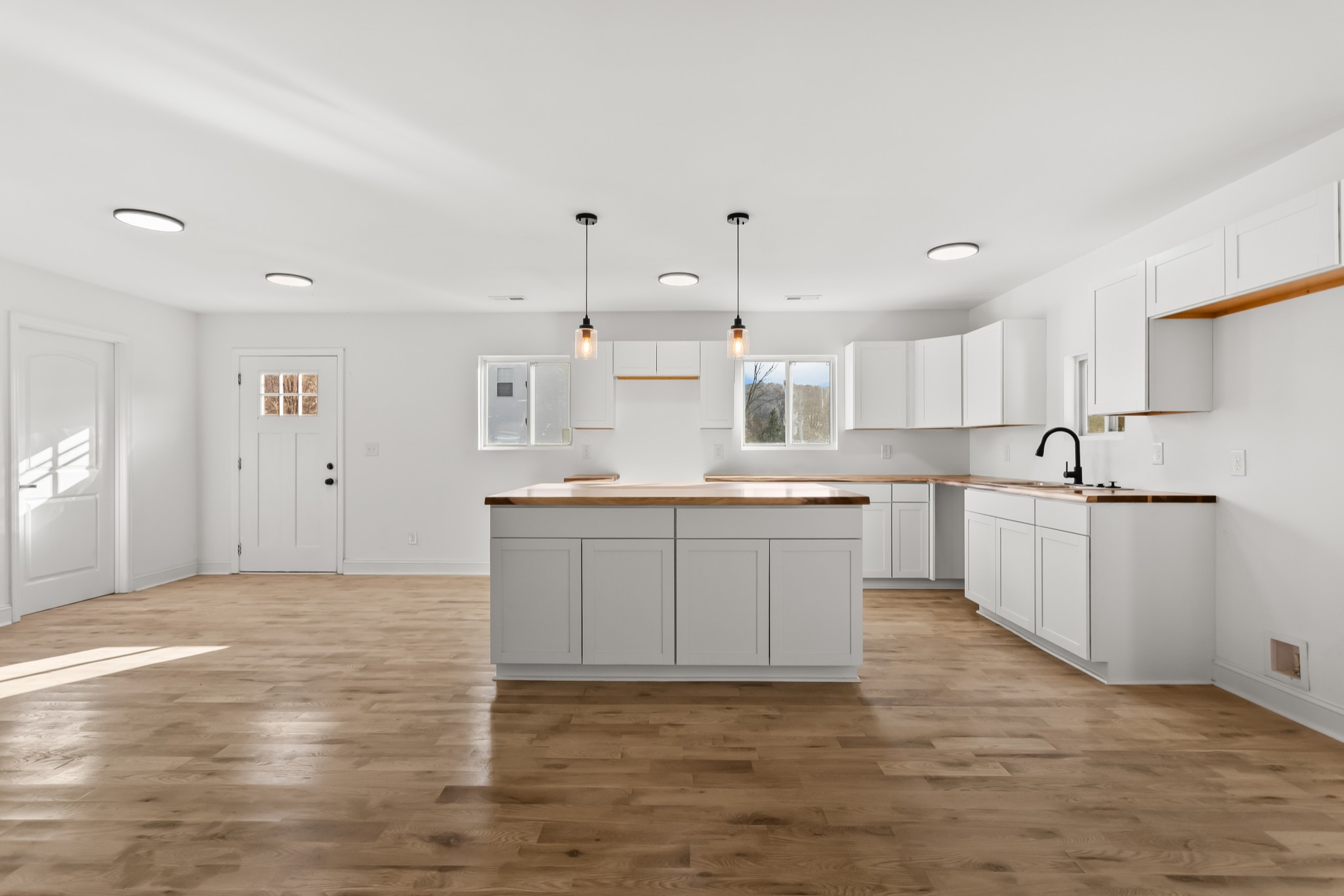 8637 Dog Branch Road Mount Pleasant, TN 38474 - Photo 8 of 44 a large white kitchen with kitchen island a sink a center island stainless steel appliances and a cabinets