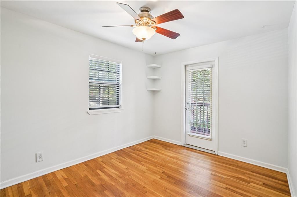 890 Glendale Terrace Northeast, Unit 1 Atlanta, GA 30309 - Photo 14 of 19 an empty room with wooden floor fan and windows