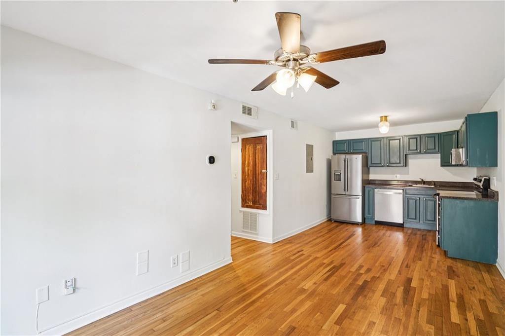 890 Glendale Terrace Northeast, Unit 1 Atlanta, GA 30309 - Photo 7 of 19 a view of a kitchen with wooden floor a sink a refrigerator and window