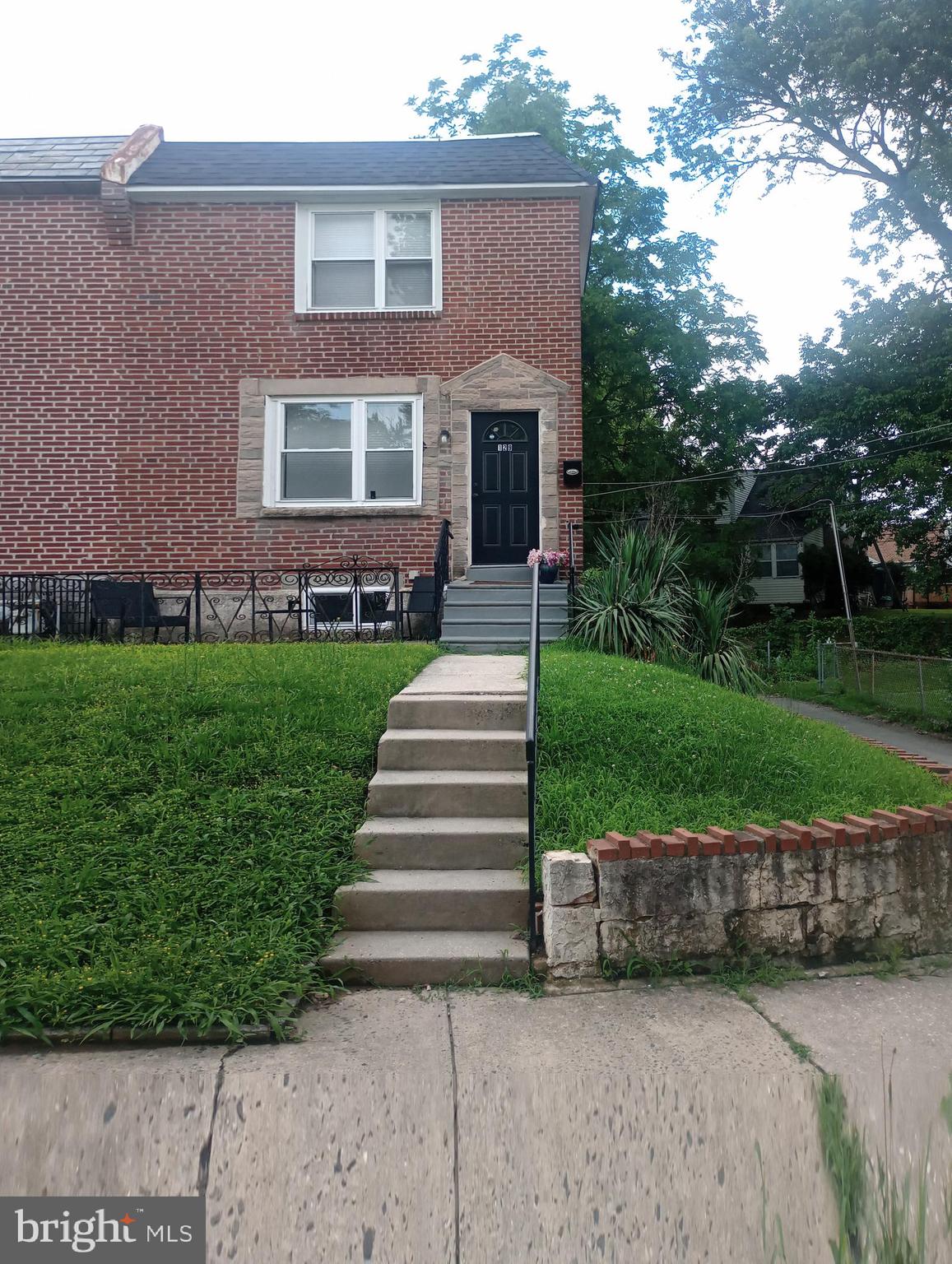 a view of a house with a yard and potted plants