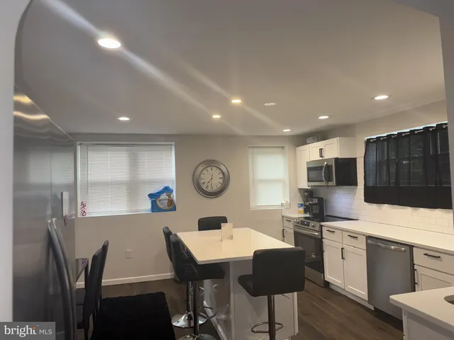 a large kitchen with a table and chairs