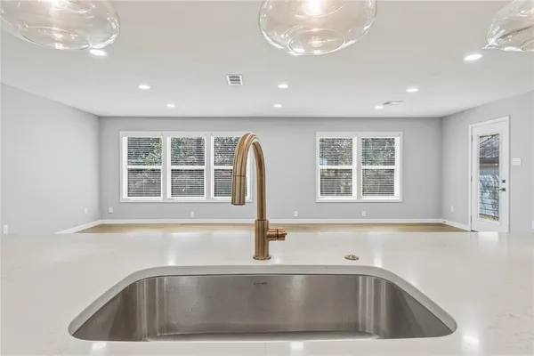 a kitchen with stainless steel appliances granite countertop a sink a stove a refrigerator and a window