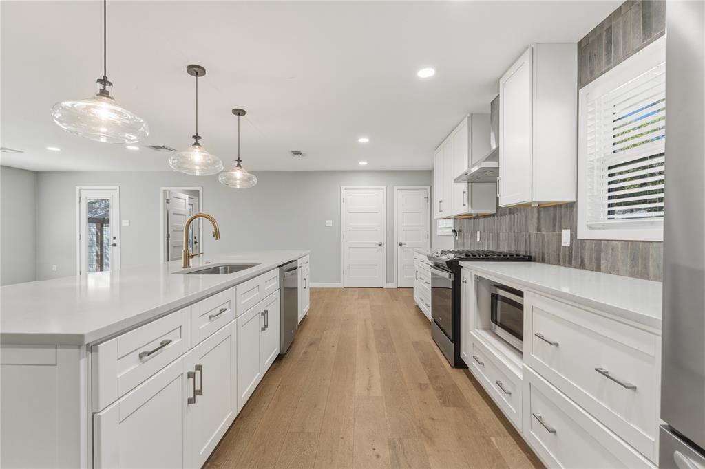 4600 Cedar Mountain Drive Waco, TX 76708 - Photo 15 of 40 a large kitchen with kitchen island white cabinets and stainless steel appliances