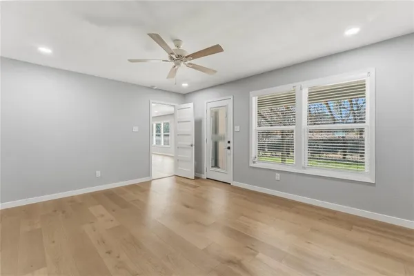 a view of an empty room with a window and wooden floor