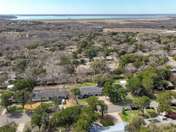 an aerial view of a house with a yard and a large tree