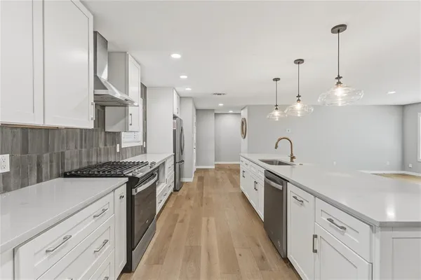 a large kitchen with stainless steel appliances granite countertop a lot of counter space and a sink