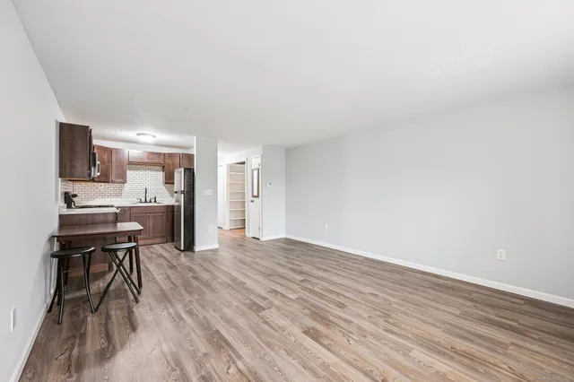 a view of kitchen with dining table chairs and refrigerator
