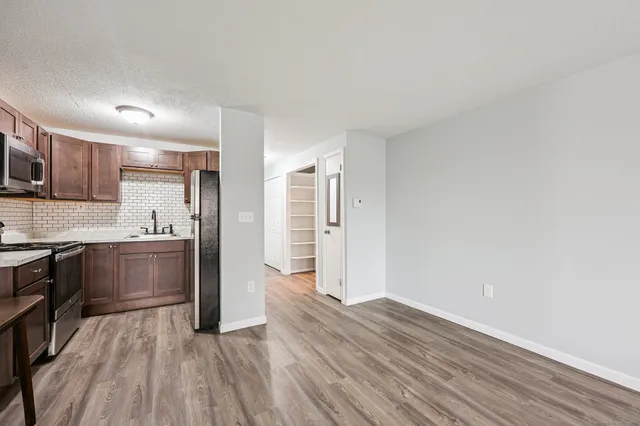 a kitchen with granite countertop wooden floors and stainless steel appliances