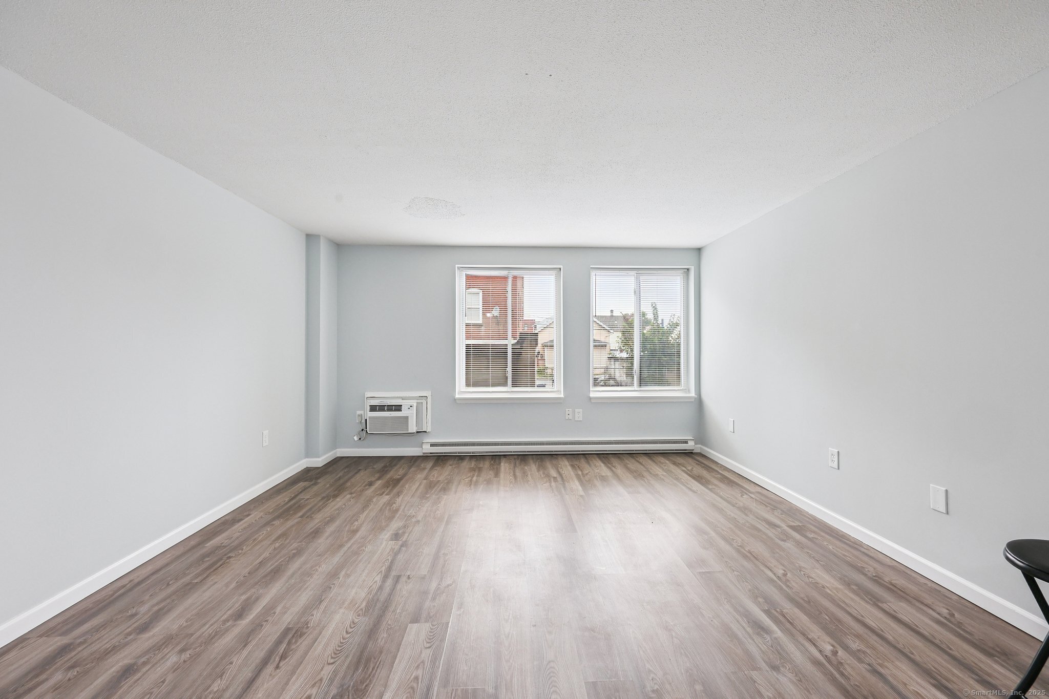 356 Franklin Avenue, Unit A4 Hartford, CT 06114 - Photo 16 of 21 an empty room with wooden floor and windows