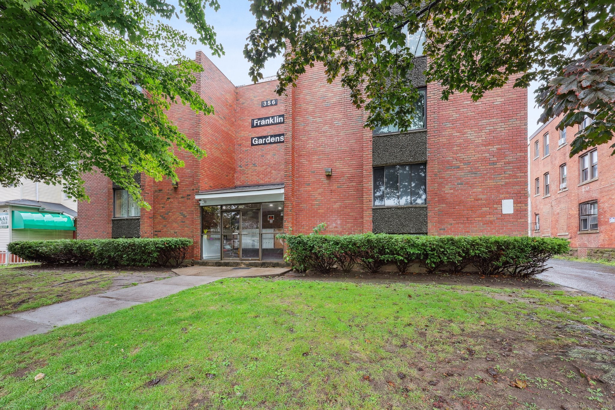 356 Franklin Avenue, Unit A4 Hartford, CT 06114 - Photo 2 of 21 a brick building with a yard in front of it